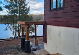 Lakeside corner of stained log home exterior