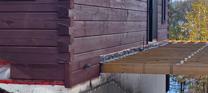 Side elevation of stained log home siding