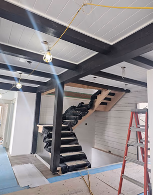Modern staircase framed by dark timber beams
