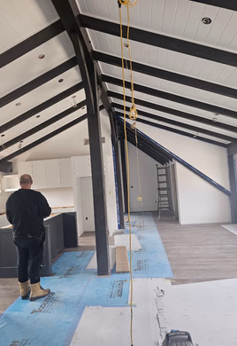 Vaulted room with exposed timber trusses and tall windows